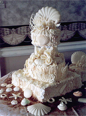 three layer seashell wedding cake with elaborate shell topper