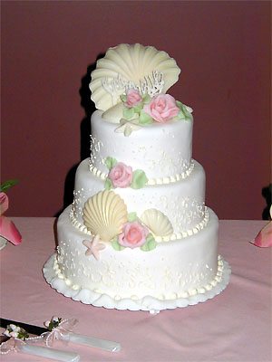 three layer pearlescent scallop cake with pink roses