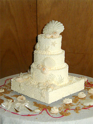 three layer round cake with square base and sea shells
