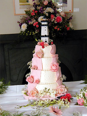 pink rose cake with lighthouse topper