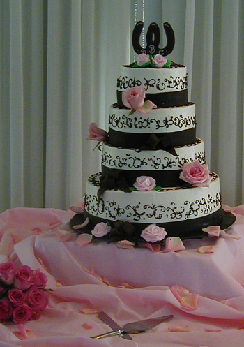 four layer white and black cake with pink roses