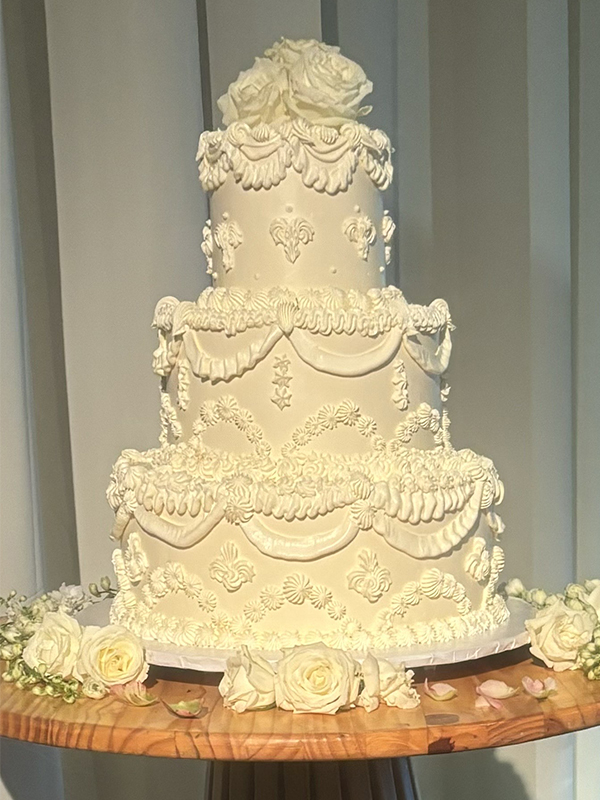 three tier ivory cake with ivory frosting flourish