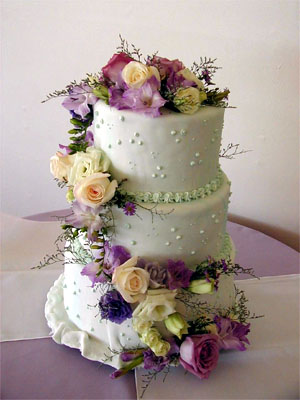 White cake with peach, pink, and purple flowers