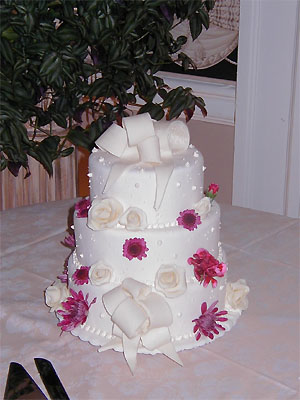 Three layer White wedding cake with white and pink flowers