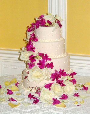 Cascading magenta flowers on a pink cake
