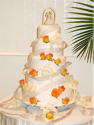 five layer cake with ribbons and orange roses