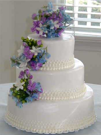 three layer cake with purple and blue flowers