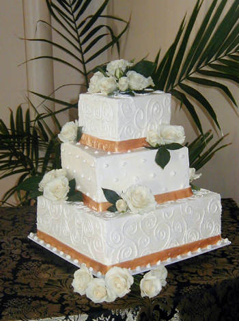 three layer square cake with ribbons and white roses